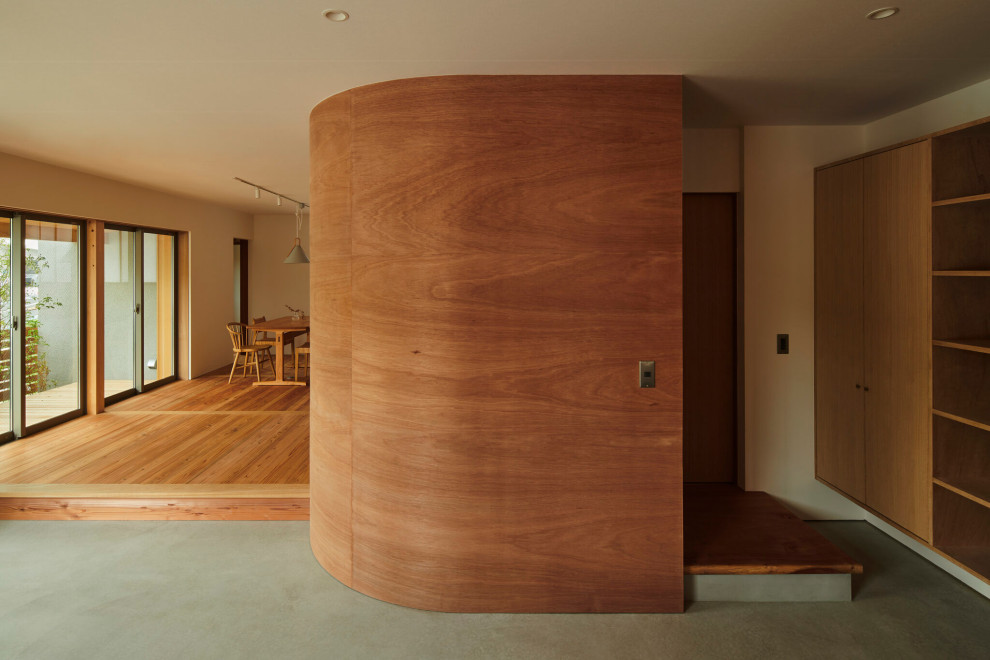 Photo of a large country entry hall in Osaka with white walls, a single front door, a dark wood front door, grey floor, wood and wallpaper.