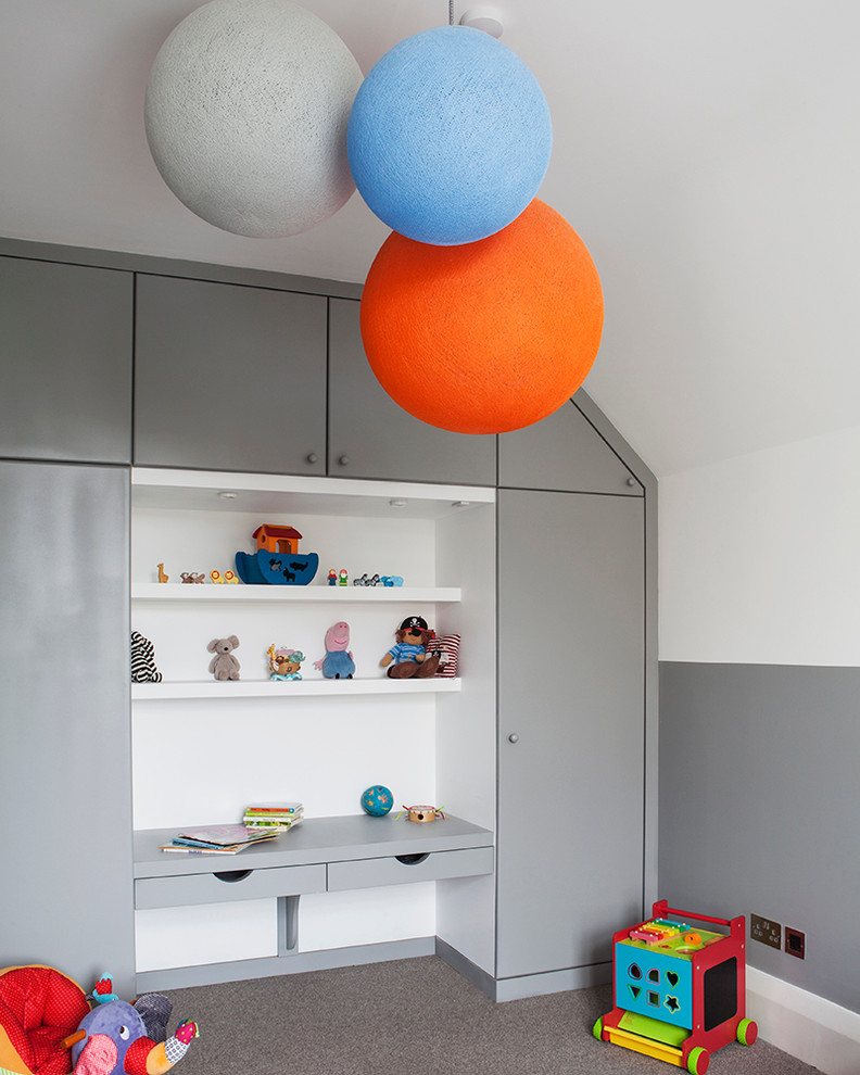 Inspiration for a mid-sized contemporary kids' room for boys in Sussex with white walls and carpet.