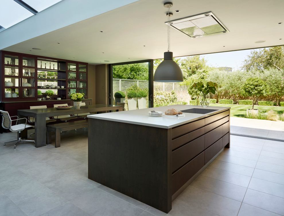 This is an example of a large contemporary open plan kitchen in London with flat-panel cabinets, quartzite benchtops, white splashback, glass tile splashback, stainless steel appliances and with island.
