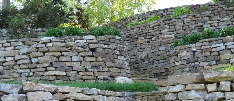 Photo of a mid-sized partial sun front yard retaining wall landscape.