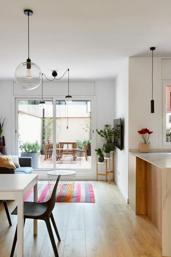 Ejemplo de comedor nórdico de tamaño medio abierto con paredes blancas, suelo laminado y suelo marrón