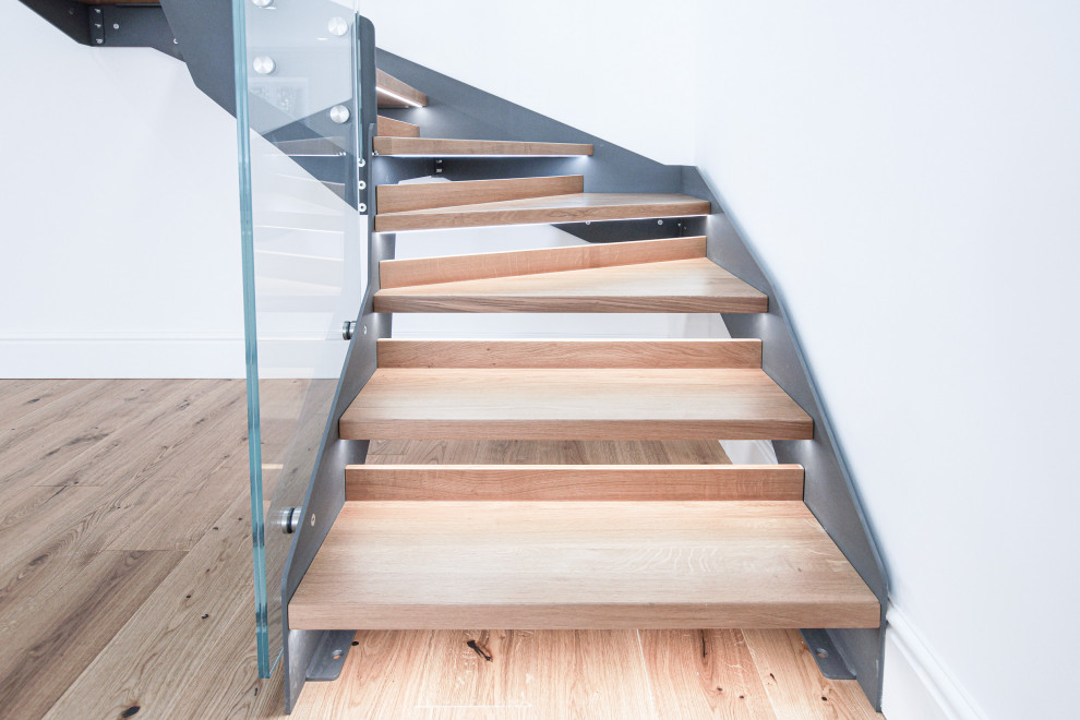 Идея дизайна: п-образная лестница среднего размера в стиле модернизм с деревянными ступенями и стеклянными перилами без подступенок