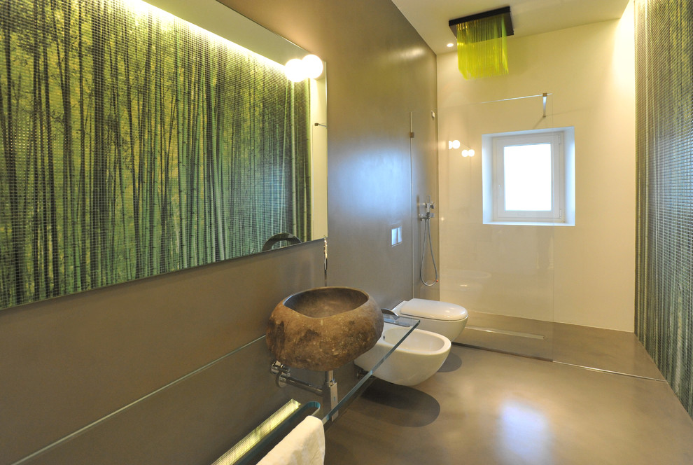 This is an example of a large contemporary master bathroom in Bari with a console sink, an open shower, a two-piece toilet, green walls, concrete floors, glass-front cabinets, grey cabinets, green tile and mosaic tile.