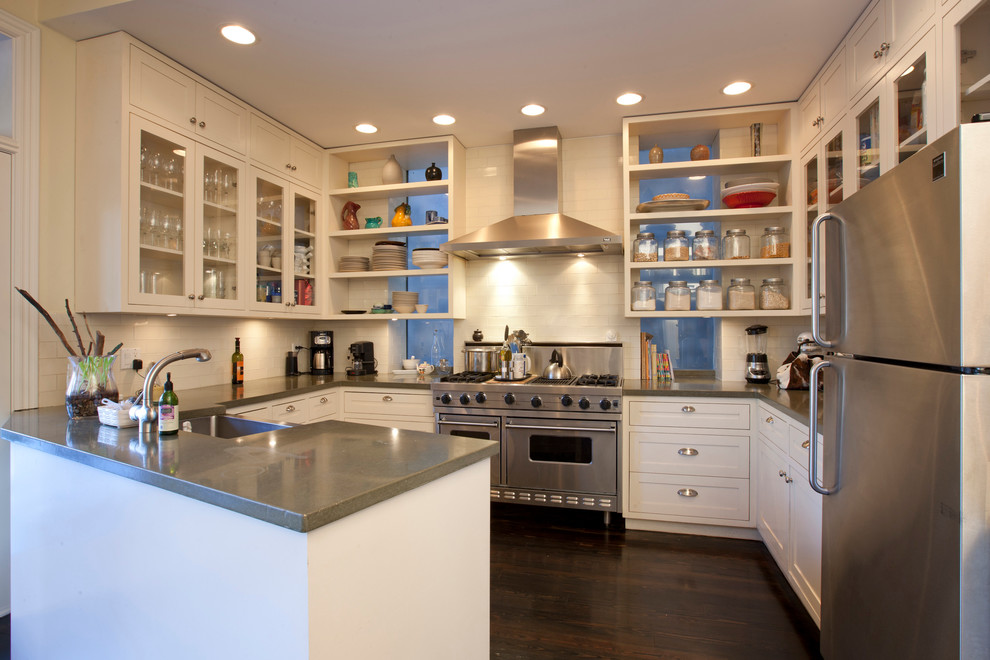 Photo of a transitional u-shaped kitchen in Chicago with a farmhouse sink, open cabinets, white cabinets, beige splashback, subway tile splashback and stainless steel appliances.