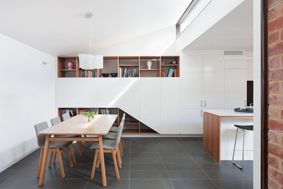 This is an example of a contemporary kitchen/dining combo in Melbourne with white walls and light hardwood floors.