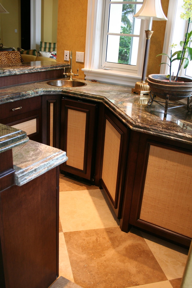 This is an example of a mid-sized traditional u-shaped wet bar in Miami with a drop-in sink, dark wood cabinets, granite benchtops and ceramic floors.