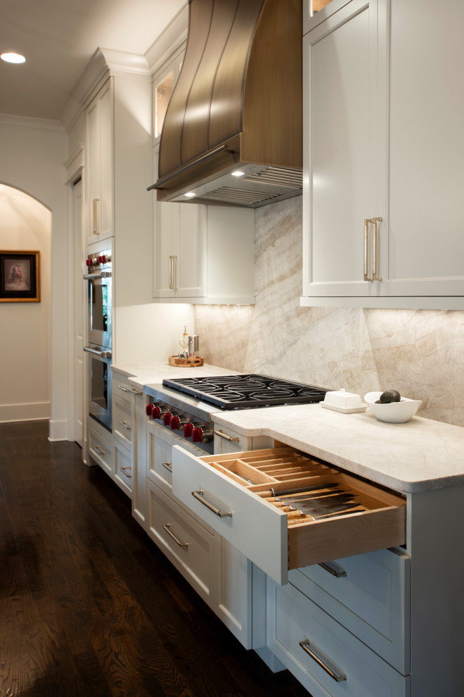 Example of a large transitional l-shaped dark wood floor and brown floor open concept kitchen design in Nashville with an undermount sink, beaded inset cabinets, white cabinets, quartzite countertops, beige backsplash, stone slab backsplash, stainless steel appliances, an island and beige countertops