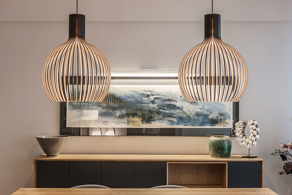 Imagen de comedor contemporáneo pequeño abierto sin chimenea con paredes grises y suelo de madera clara