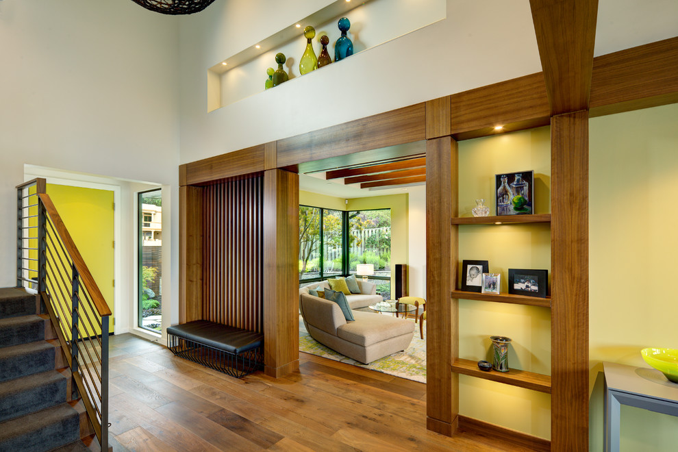 This is an example of a mid-sized midcentury foyer in San Francisco with white walls, medium hardwood floors, a single front door and a yellow front door.