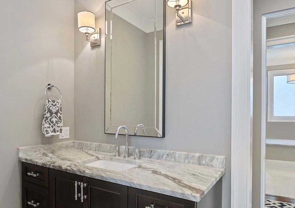 Photo of a large traditional master bathroom in DC Metro with flat-panel cabinets, brown cabinets, a drop-in tub, a shower/bathtub combo, gray tile, ceramic tile, grey walls, ceramic floors, a console sink, engineered quartz benchtops, white floor, a hinged shower door and white benchtops.