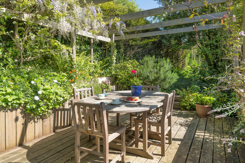 Inspiration for a mid-sized country side yard deck in Devon with a pergola.