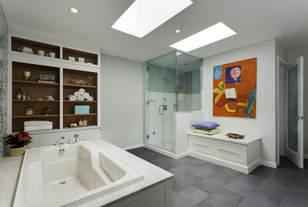 Photo of a traditional bathroom in DC Metro with shaker cabinets, white cabinets, a drop-in tub, a corner shower and grey floor.