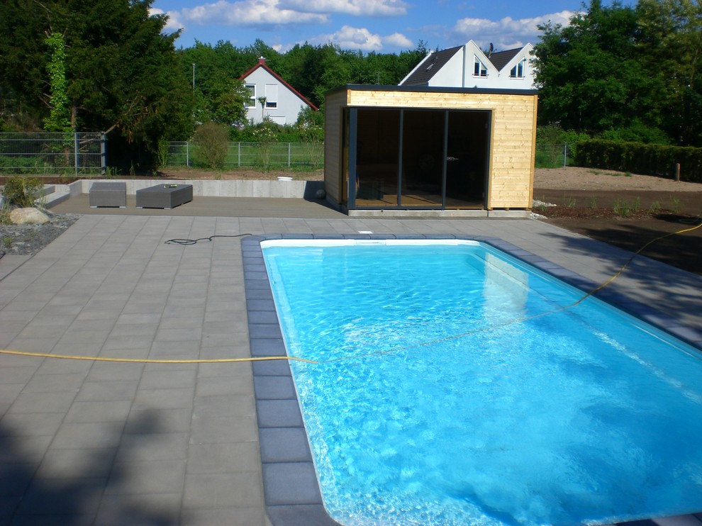 Oberirdisches, Großes Modernes Poolhaus hinter dem Haus in rechteckiger Form mit Pflastersteinen in Frankfurt am Main