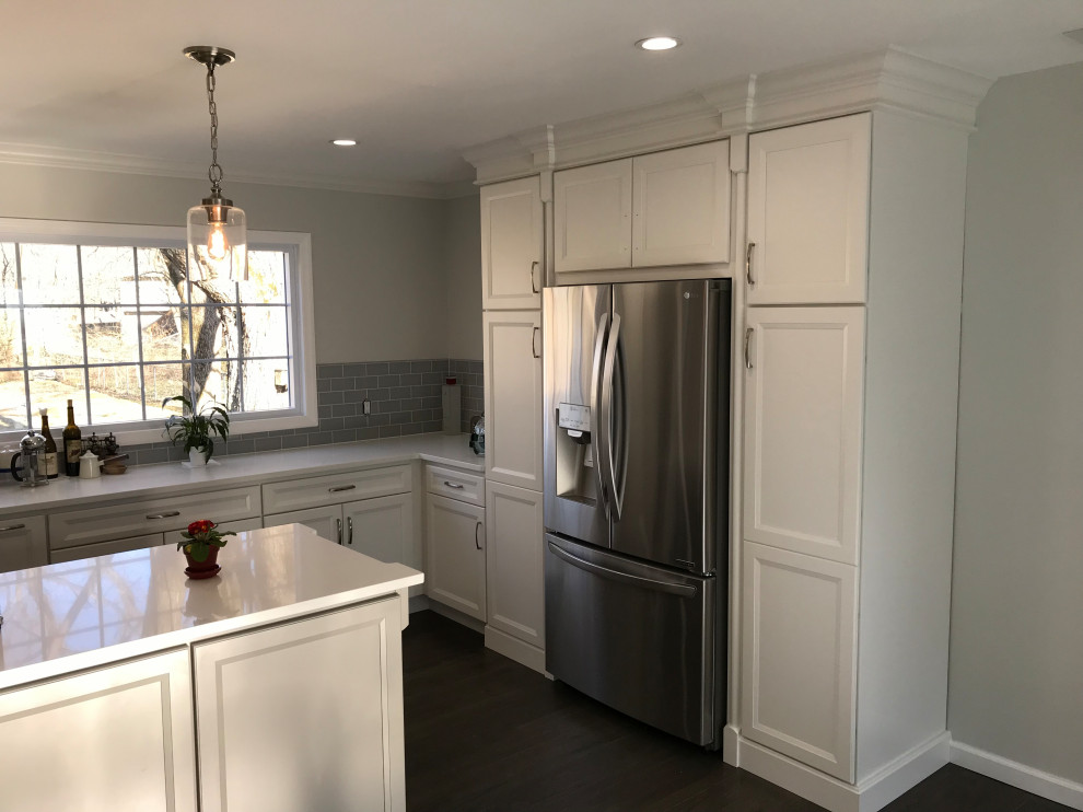 Example of a large transitional u-shaped ceramic tile and gray floor eat-in kitchen design with a farmhouse sink, recessed-panel cabinets, white cabinets, quartz countertops, gray backsplash, subway tile backsplash, stainless steel appliances, an island and white countertops