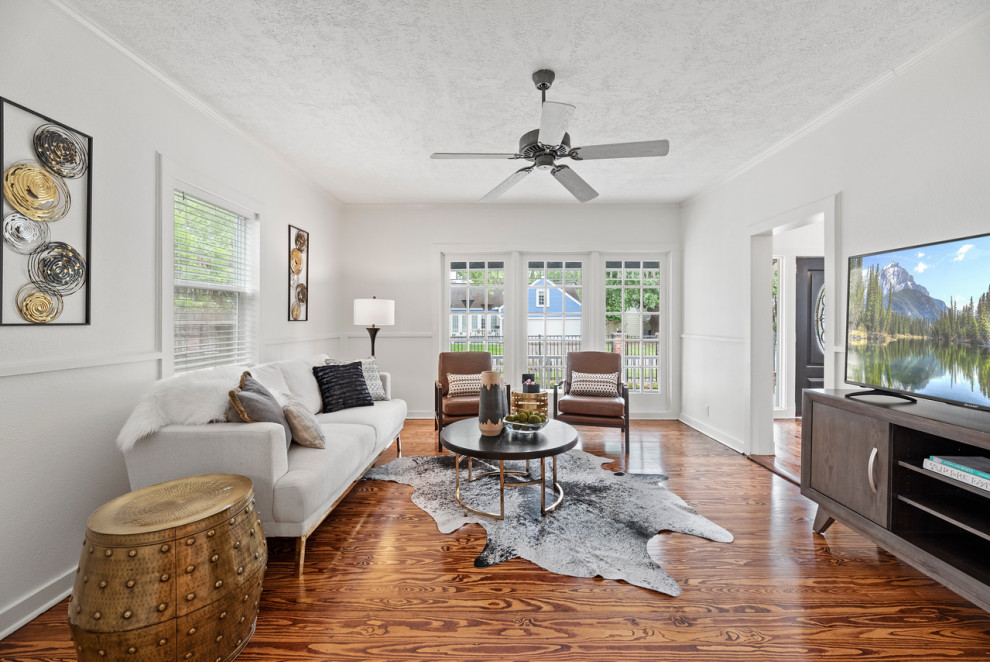 Kleines Stilmix Wohnzimmer mit weißer Wandfarbe und braunem Holzboden in Houston