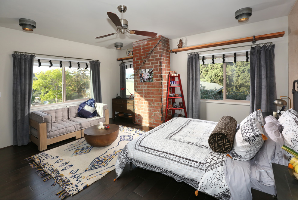 This is an example of a mid-sized industrial guest bedroom in Los Angeles with beige walls and dark hardwood floors.