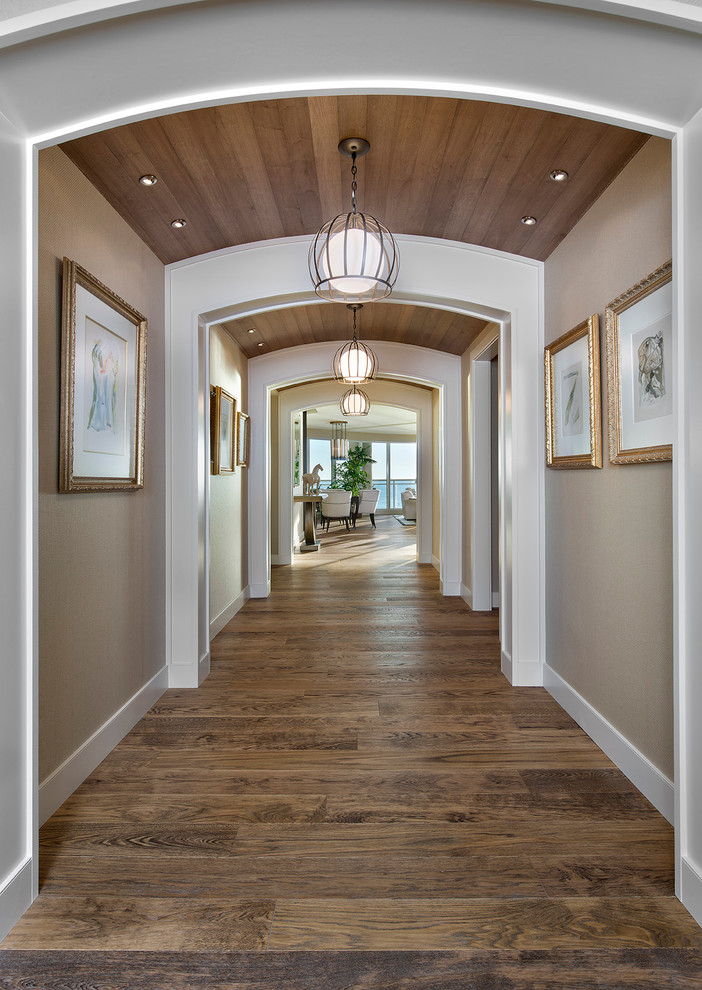 Photo of a large traditional hallway in Miami with beige walls, dark hardwood floors and brown floor.