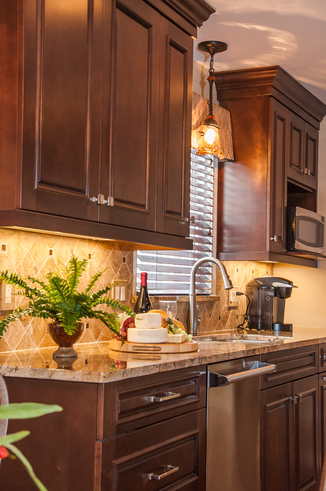 Traditional galley eat-in kitchen in Detroit with an undermount sink, raised-panel cabinets, brown cabinets, granite benchtops, brown splashback, stone tile splashback and stainless steel appliances.