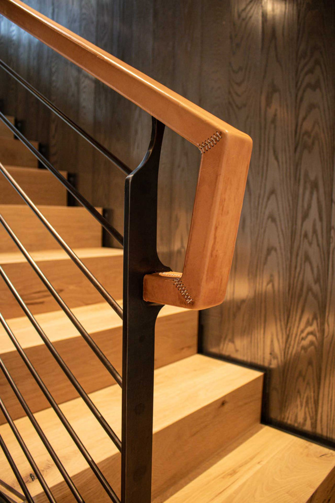 Réalisation d'un escalier droit avec des marches en bois, des contremarches en bois, un garde-corps en métal et du lambris.