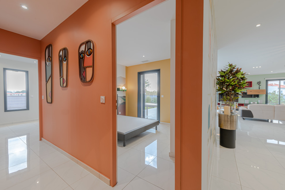This is an example of a mid-sized modern hallway in Toulouse with orange walls, ceramic floors and beige floor.