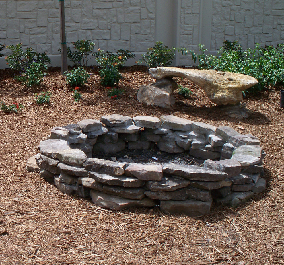 Photo of a mid-sized traditional backyard full sun garden in Tampa with a fire feature and mulch.