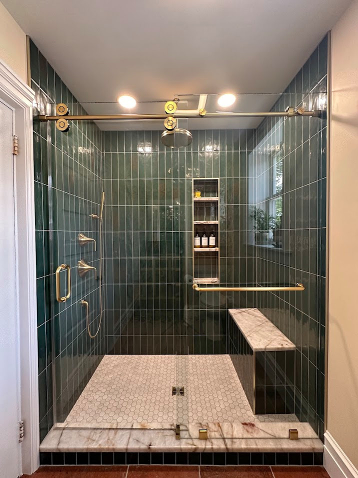 A stunning master bathroom blending natural elegance with timeless charm, featuring a full walk-in shower adorned with vertical green tiles that evoke a serene, spa-like atmosphere. The Mediterranean-
