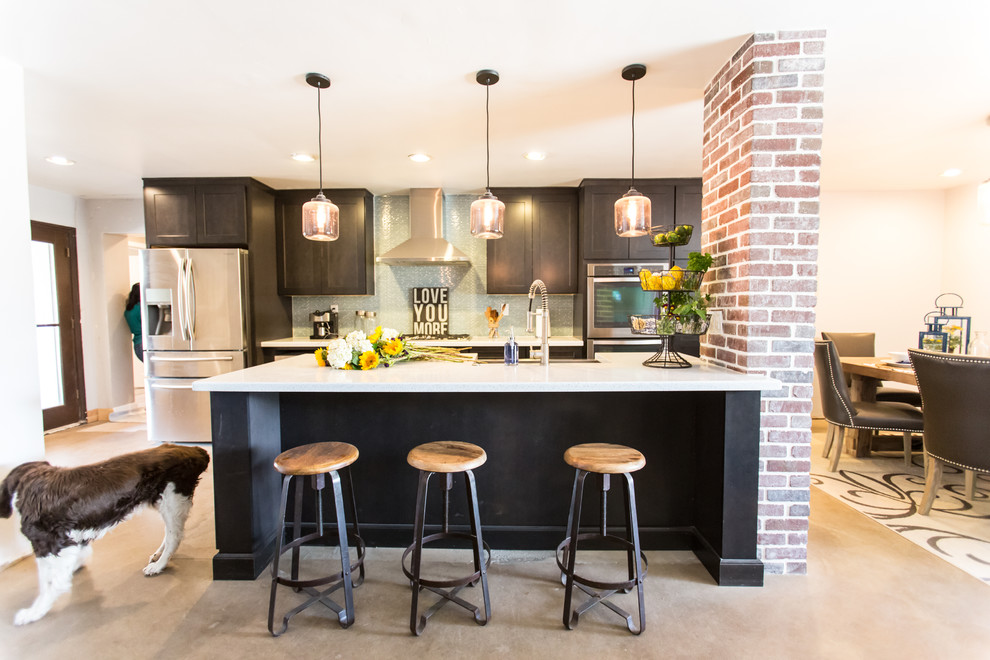 Example of a mid-sized mountain style single-wall concrete floor and gray floor open concept kitchen design in Phoenix with dark wood cabinets, blue backsplash, stainless steel appliances, an island, an undermount sink, shaker cabinets, quartzite countertops and glass tile backsplash