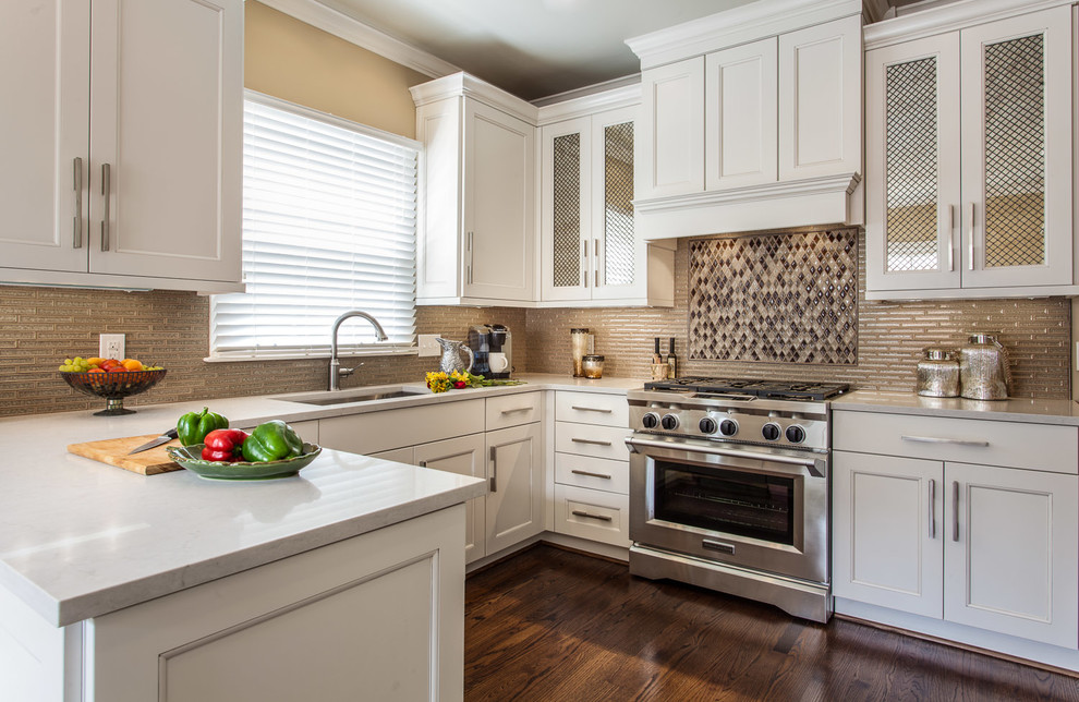 Design ideas for a mid-sized traditional u-shaped kitchen in Nashville with an undermount sink, recessed-panel cabinets, white cabinets, quartz benchtops, beige splashback, glass tile splashback, stainless steel appliances, dark hardwood floors and a peninsula.