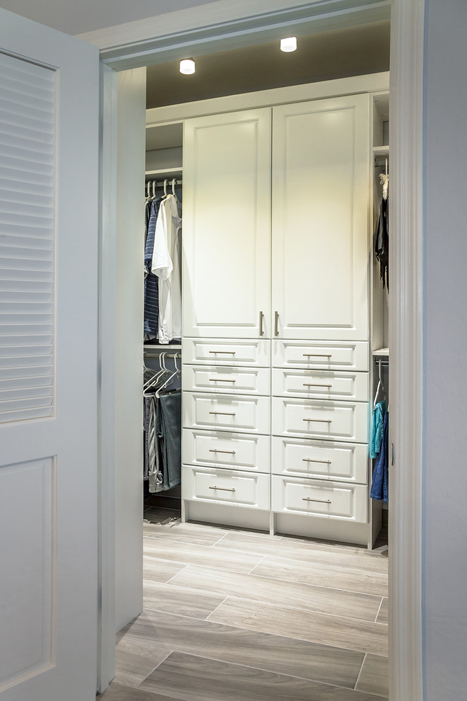 Mid-sized transitional storage and wardrobe in Phoenix with recessed-panel cabinets, distressed cabinets, porcelain floors and brown floor.