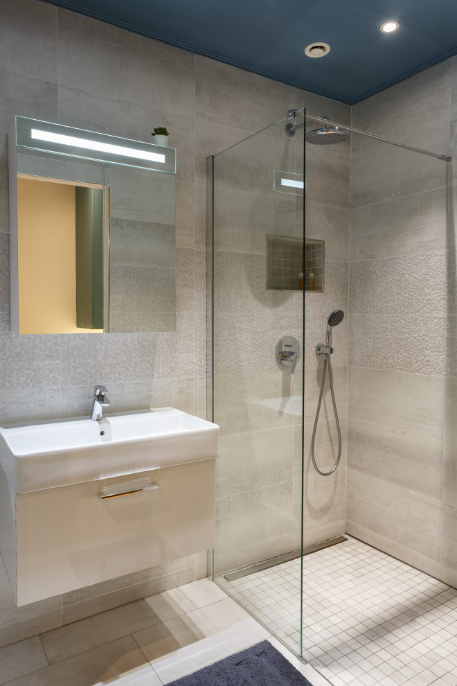 Esempio di una stanza da bagno con doccia a filo pavimento, piastrelle grigie, piastrelle in travertino e lavabo a consolle