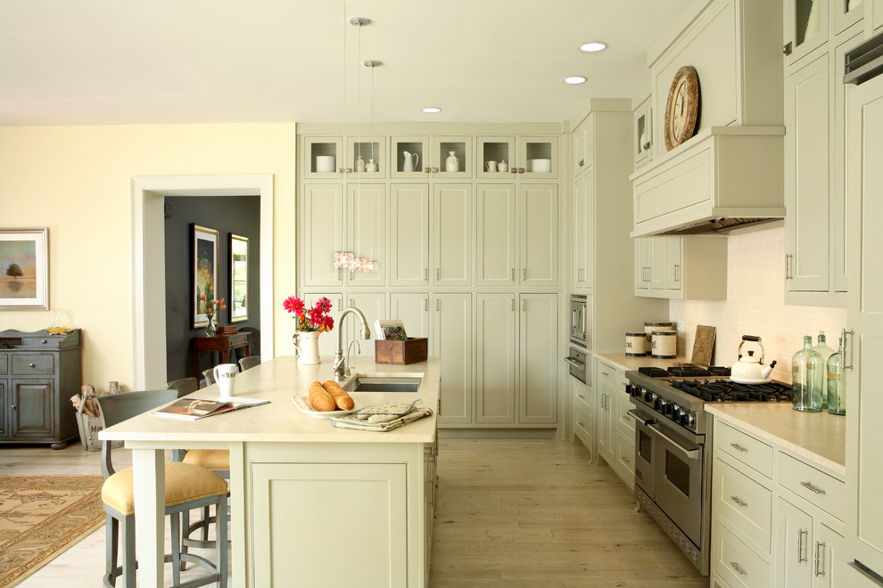 Inspiration for a traditional u-shaped kitchen in Atlanta with stainless steel appliances, a single-bowl sink, grey cabinets, white splashback, subway tile splashback and beaded inset cabinets.