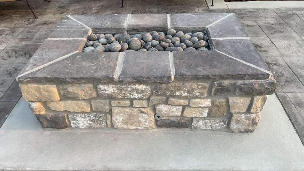 Inspiration for a mid-sized country backyard patio in Denver with with fireplace and concrete pavers.