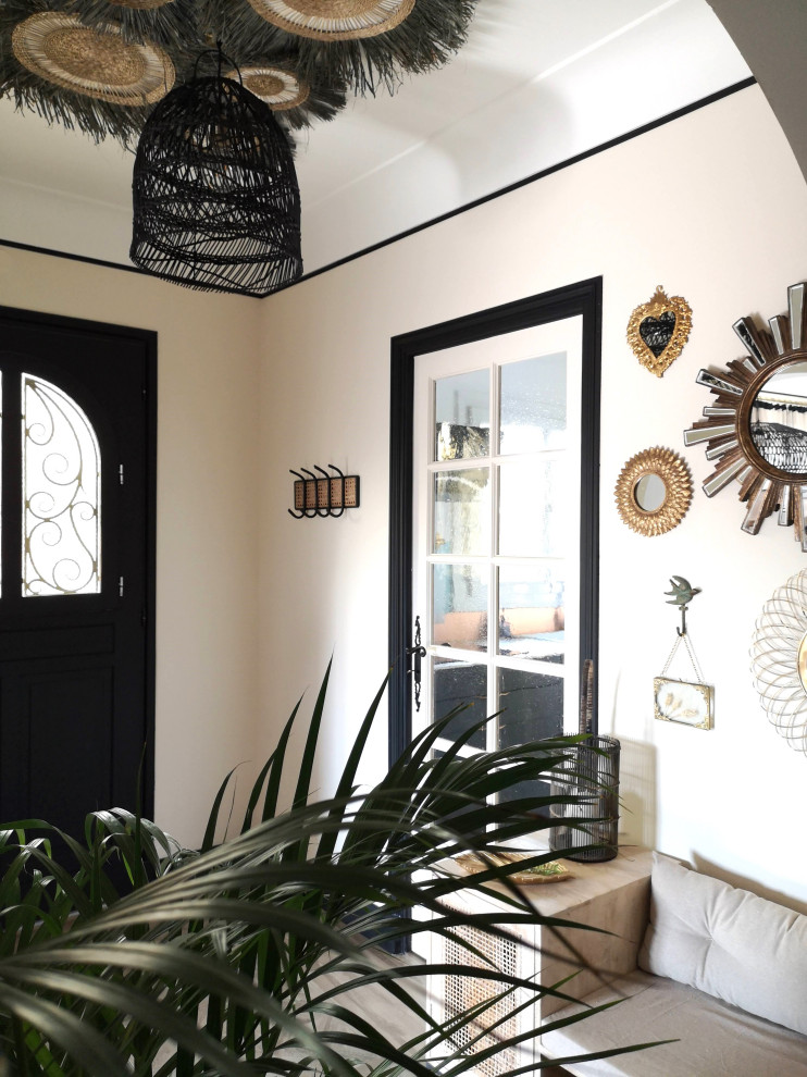 This is an example of a mediterranean foyer in Other with beige walls and a black front door.