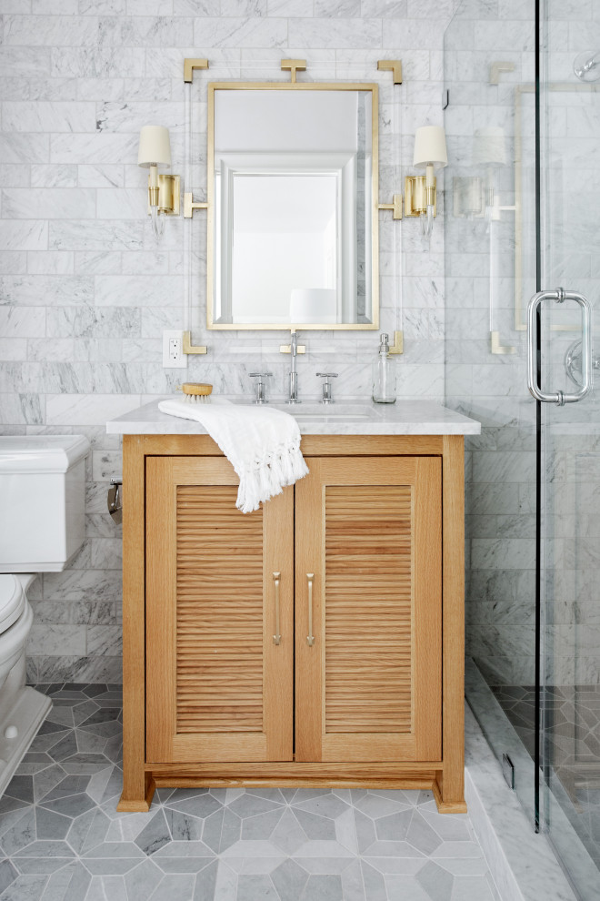 На фото: ванная комната среднего размера в стиле неоклассика (современная классика) с фасадами с филенкой типа жалюзи, коричневыми фасадами, раздельным унитазом, белой плиткой, мраморной плиткой, белыми стенами, мраморным полом, врезной раковиной, мраморной столешницей, желтым полом, душем с распашными дверями, белой столешницей, тумбой под одну раковину и напольной тумбой с