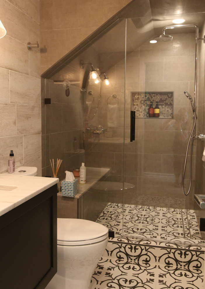 This is an example of a mid-sized country master wet room bathroom in Los Angeles with black cabinets, a one-piece toilet, multi-coloured tile, brown walls, ceramic floors, an undermount sink, multi-coloured floor, a hinged shower door, white benchtops, a shower seat, a single vanity and a floating vanity.