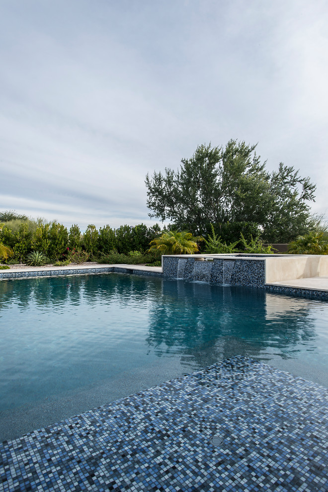 Design ideas for a large modern backyard rectangular pool in Phoenix with a hot tub and natural stone pavers.