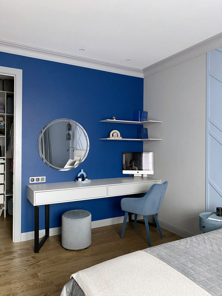 Источник вдохновения для домашнего уюта: хозяйская спальня среднего размера в стиле неоклассика (современная классика) с синими стенами, паркетным полом среднего тона, коричневым полом, панелями на части стены и рабочим местом без камина