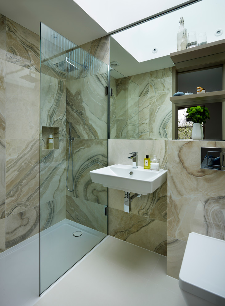 This is an example of a contemporary master bathroom in London with a wall-mount sink, a wall-mount toilet, porcelain tile, an alcove shower and beige tile.