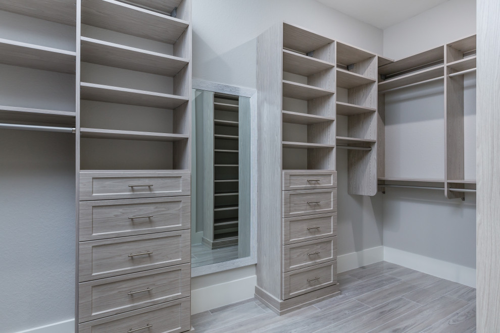 Design ideas for a large mediterranean gender-neutral walk-in wardrobe in Miami with raised-panel cabinets, light wood cabinets, ceramic floors, grey floor and recessed.