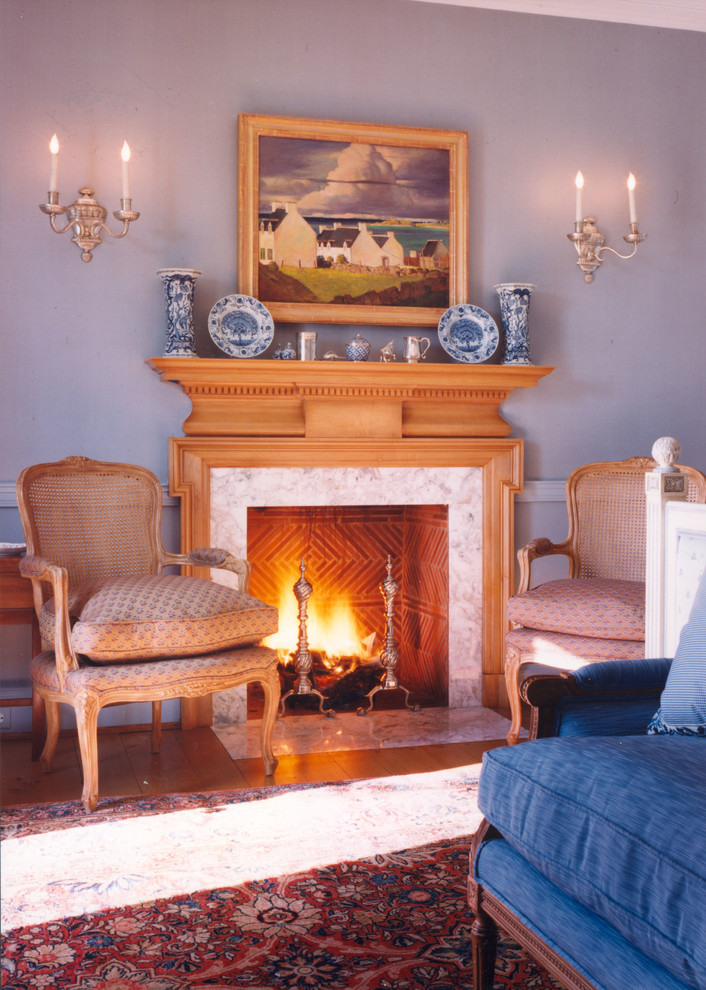 This is an example of a traditional formal enclosed living room in New York with blue walls, medium hardwood floors and a standard fireplace.