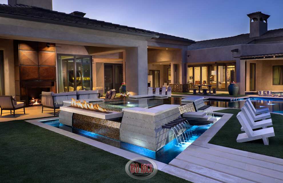 Photo of an expansive country backyard custom-shaped infinity pool in Phoenix with a water feature and natural stone pavers.