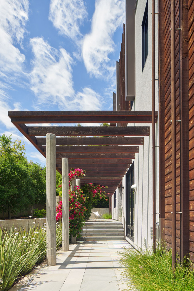 Large minimalist gray two-story stucco exterior home photo in San Francisco with a metal roof and a brown roof