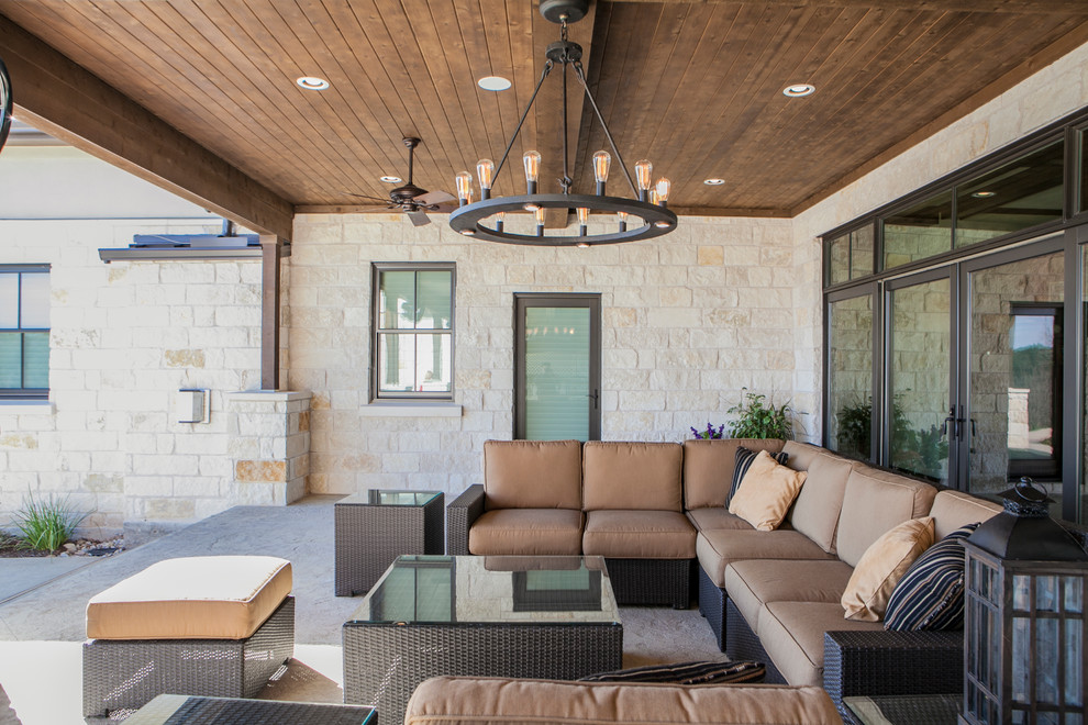 Design ideas for a large transitional backyard patio in Austin with concrete slab and a roof extension.