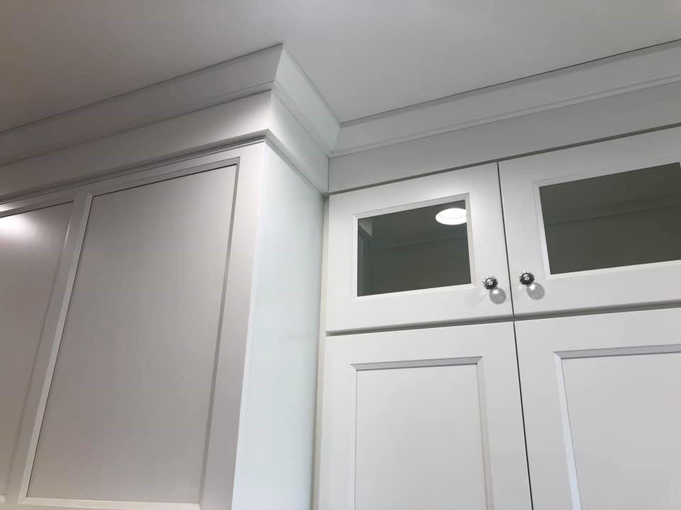 Inspiration for a large transitional l-shaped medium tone wood floor kitchen remodel with an undermount sink, shaker cabinets, white cabinets, quartz countertops, stainless steel appliances, a peninsula and white countertops