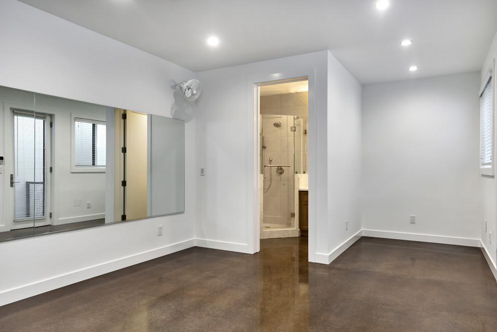 Idee per una piccola palestra multiuso stile americano con pareti bianche, pavimento in cemento e pavimento marrone