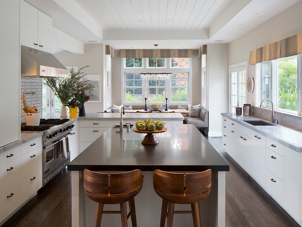 Photo of a large transitional galley separate kitchen in San Francisco with an undermount sink, flat-panel cabinets, white cabinets, white splashback, porcelain splashback, stainless steel appliances, dark hardwood floors, with island, brown floor, quartzite benchtops and white benchtop.