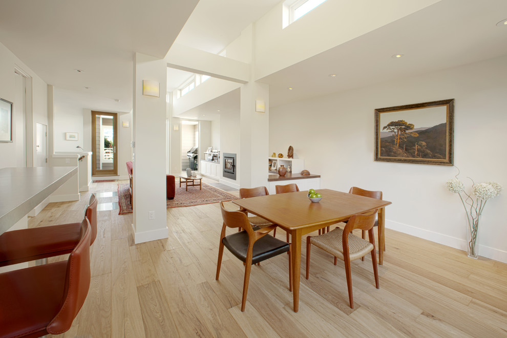 Photo of a mid-sized contemporary separate dining room in San Francisco with white walls, light hardwood floors, no fireplace and brown floor.