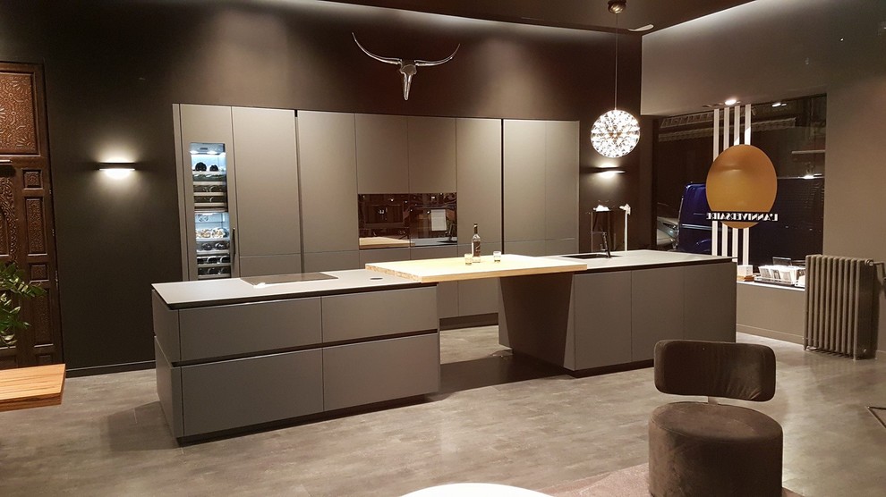 Design ideas for a large modern galley open plan kitchen in Grenoble with an integrated sink, grey cabinets, laminate benchtops and multiple islands.