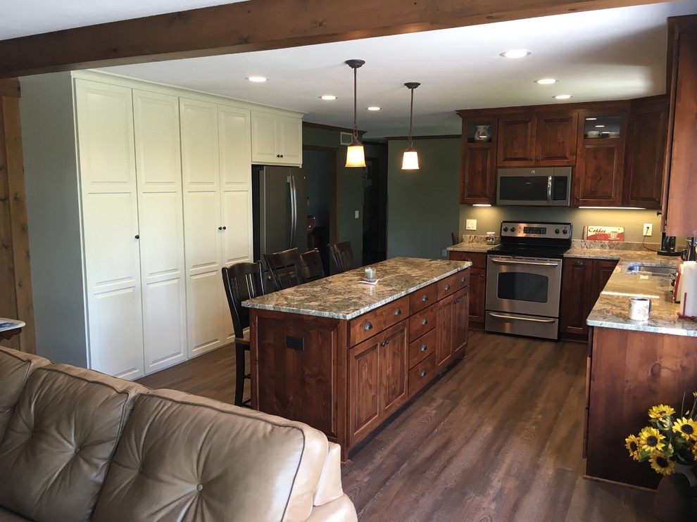 Example of a large transitional u-shaped open concept kitchen design with an undermount sink, raised-panel cabinets, dark wood cabinets, granite countertops, stainless steel appliances and an island