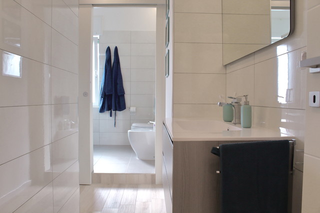 Idee per una stanza da bagno con doccia design di medie dimensioni con ante con riquadro incassato, ante in legno scuro, doccia a filo pavimento, WC a due pezzi, piastrelle bianche, piastrelle in gres porcellanato, pareti bianche, pavimento in gres porcellanato, lavabo integrato, top in superficie solida, pavimento beige e porta doccia scorrevole